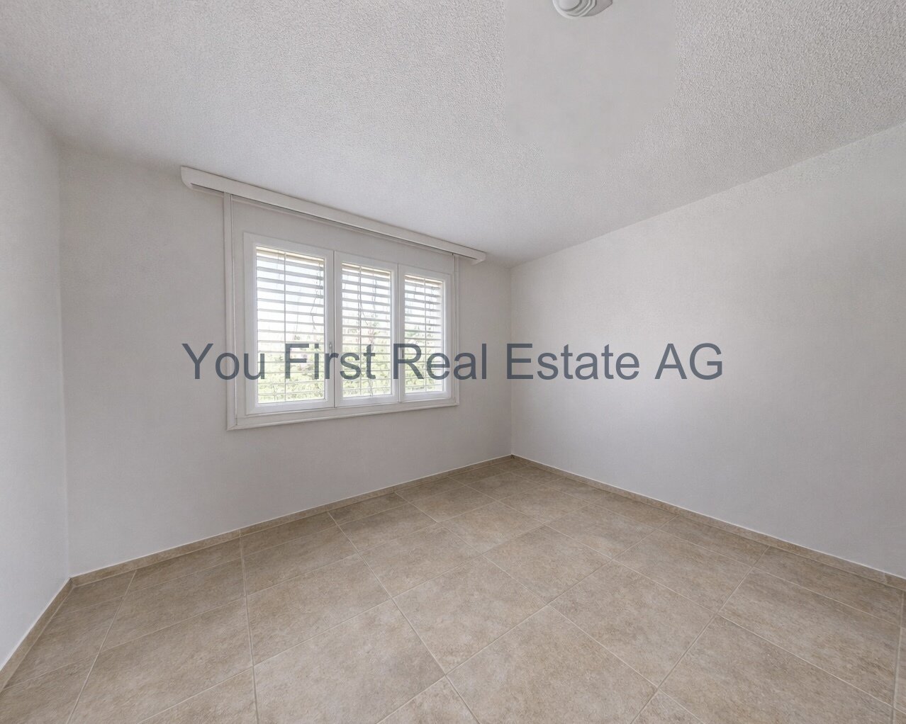 Helles Zimmer mit Fensterfront und Jalousien