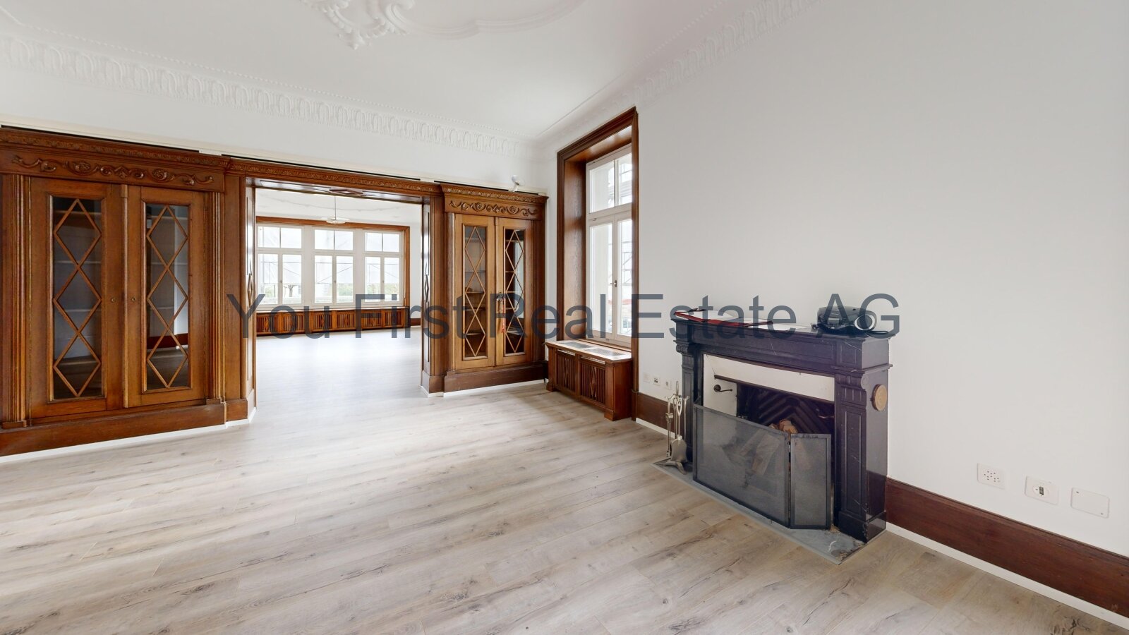 Repräsentativer Salon mit klassischen Holzglastüren und eleganter Kaminanlage