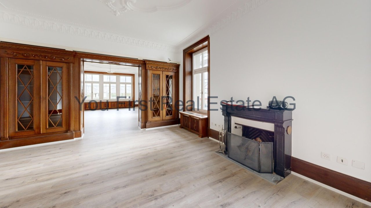 Repräsentativer Salon mit klassischen Holzglastüren und eleganter Kaminanlage