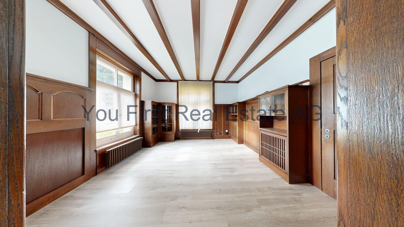 Imposanter Salon mit charaktervollen Deckenbalken und eleganten Holzverkleidungen