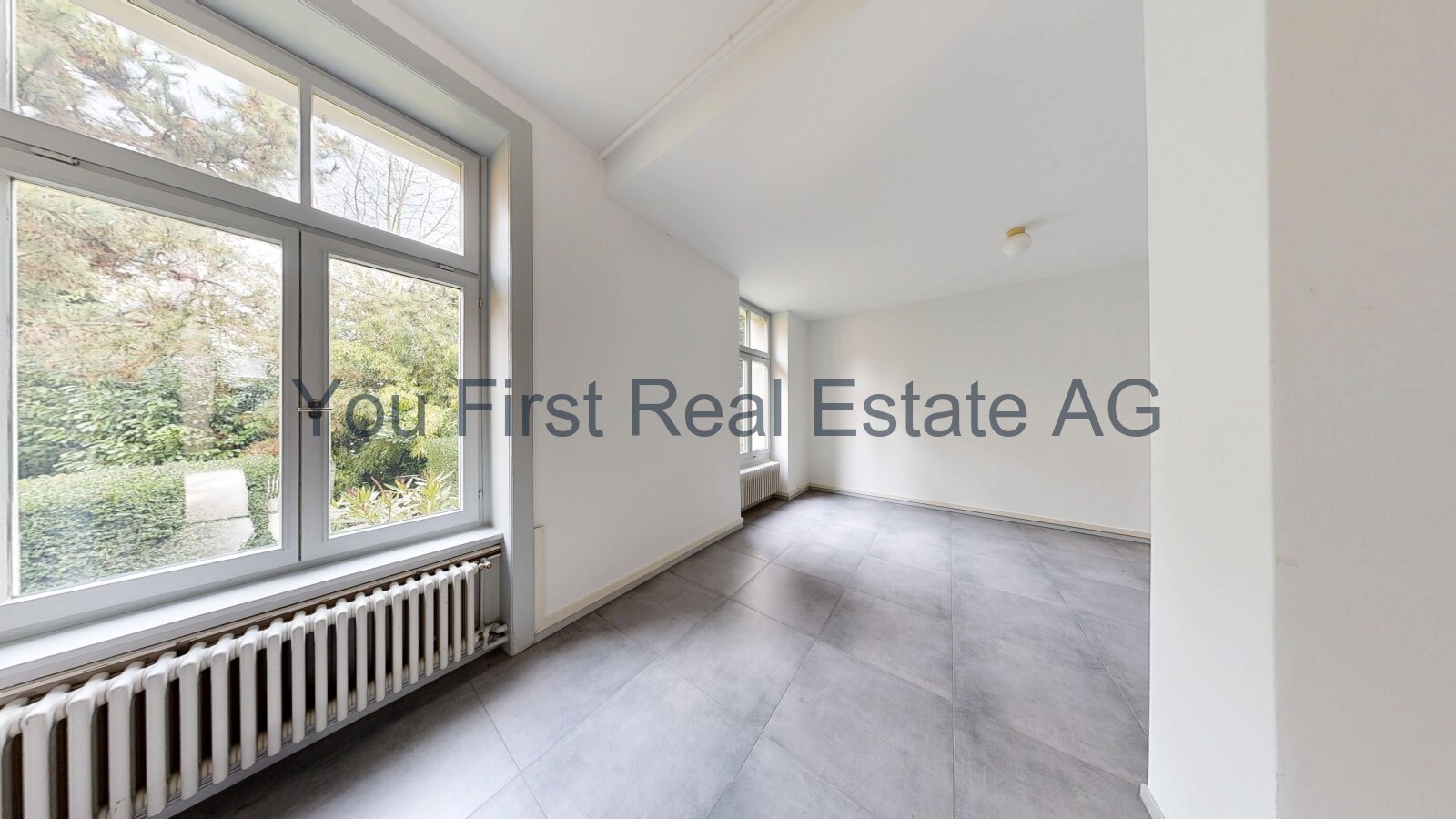 Helles Eckzimmer mit bodentiefer Fensterfront und Gartenblick