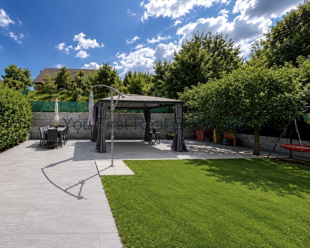 Terrassenbereich mit hochwertiger Natursteinanlage und integrierter Pergola
