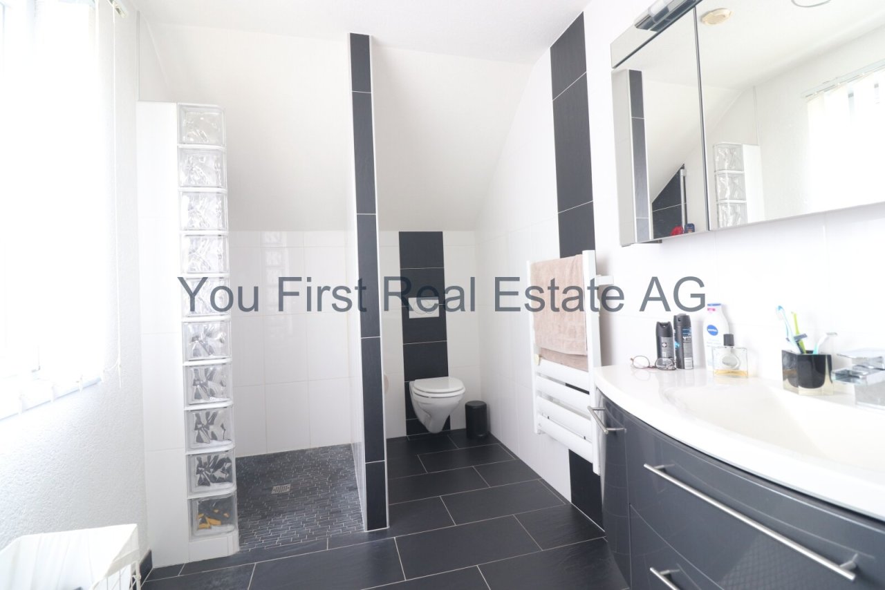 Modernes Badezimmer mit Walk-In-Dusche und großflächigem Spiegelschrank