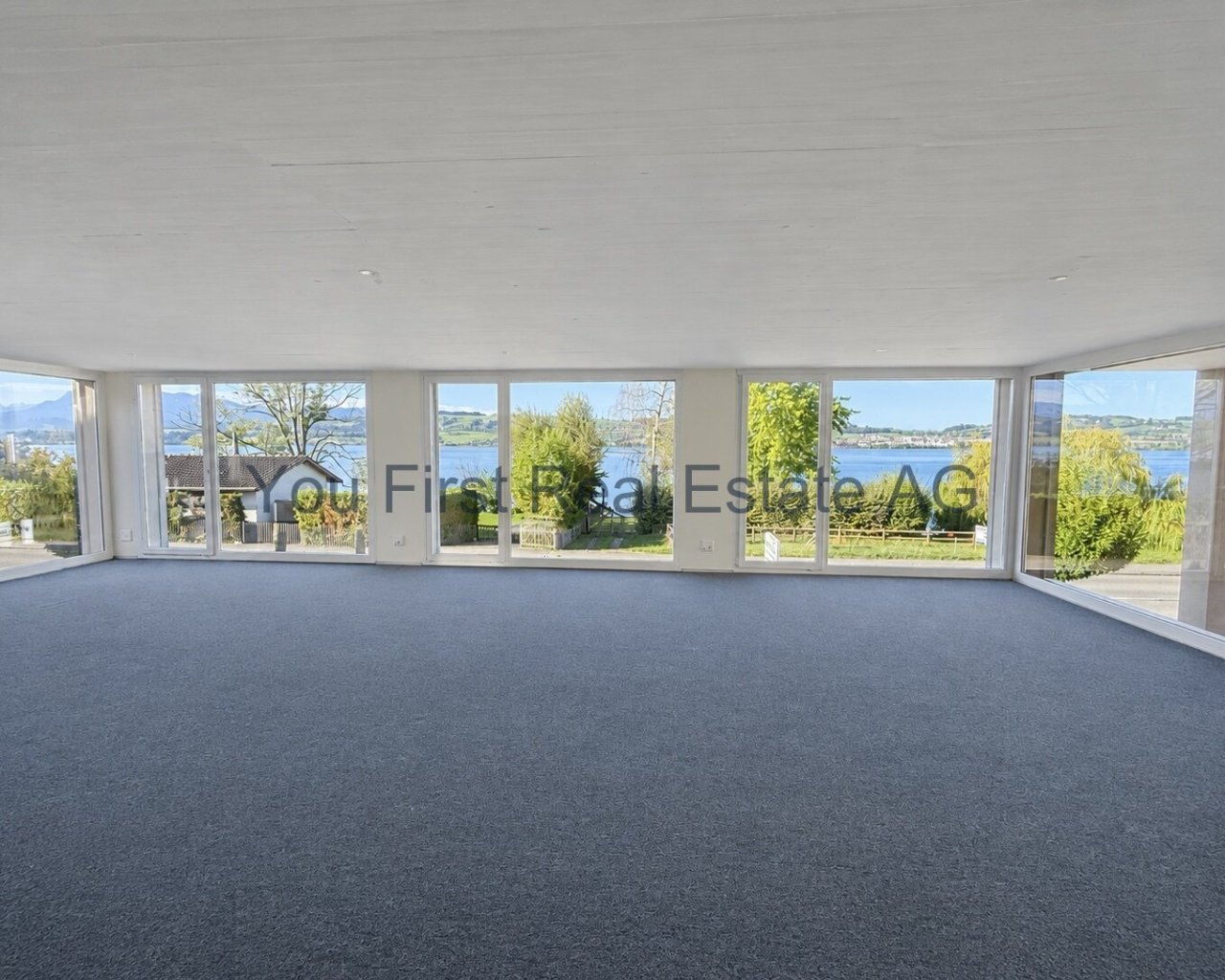 Helle Büroräulichkeiten mit Panoramafenstern und Seenblick