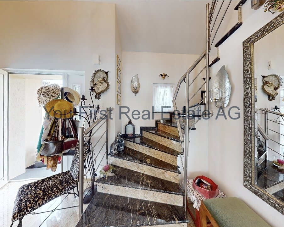 Exklusiver Eingangsbereich mit edler Naturstein-Treppe und designtem Geländer