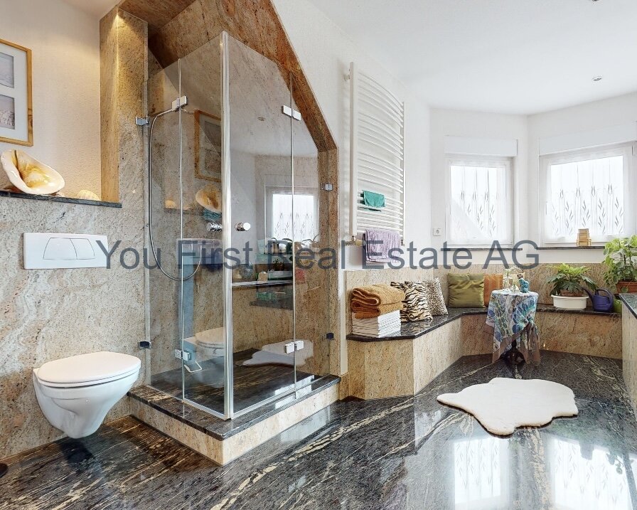 Luxuriöses Badezimmer mit Naturstein und Panorama-Glasdusche - Wohlfühloase auf höchstem Niveau