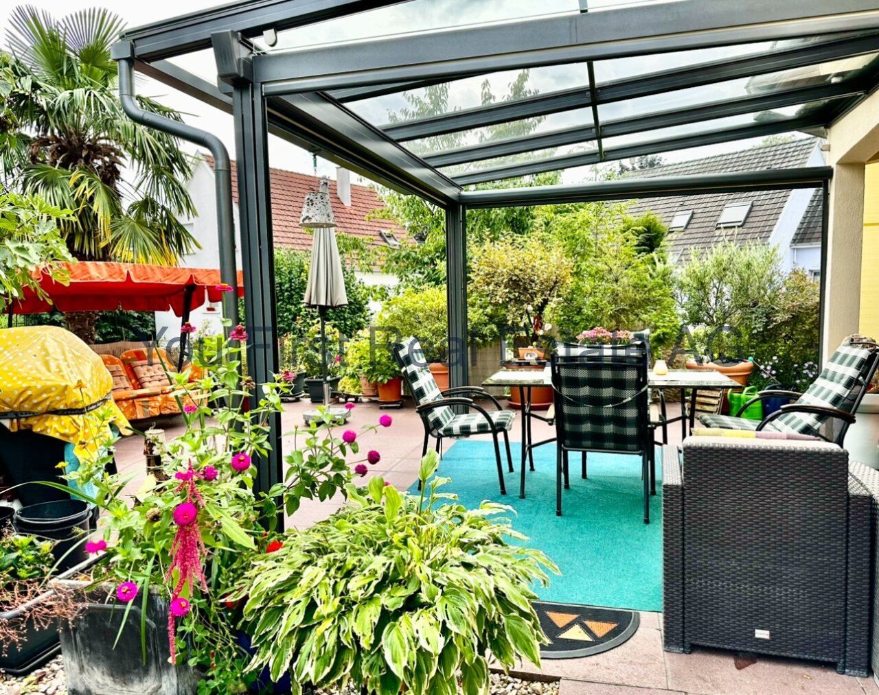 Lichtdurchflutete Terrasse mit Wintergarten: Moderne Wohlfühloase mit Glasüberdachung und tropischem Flair