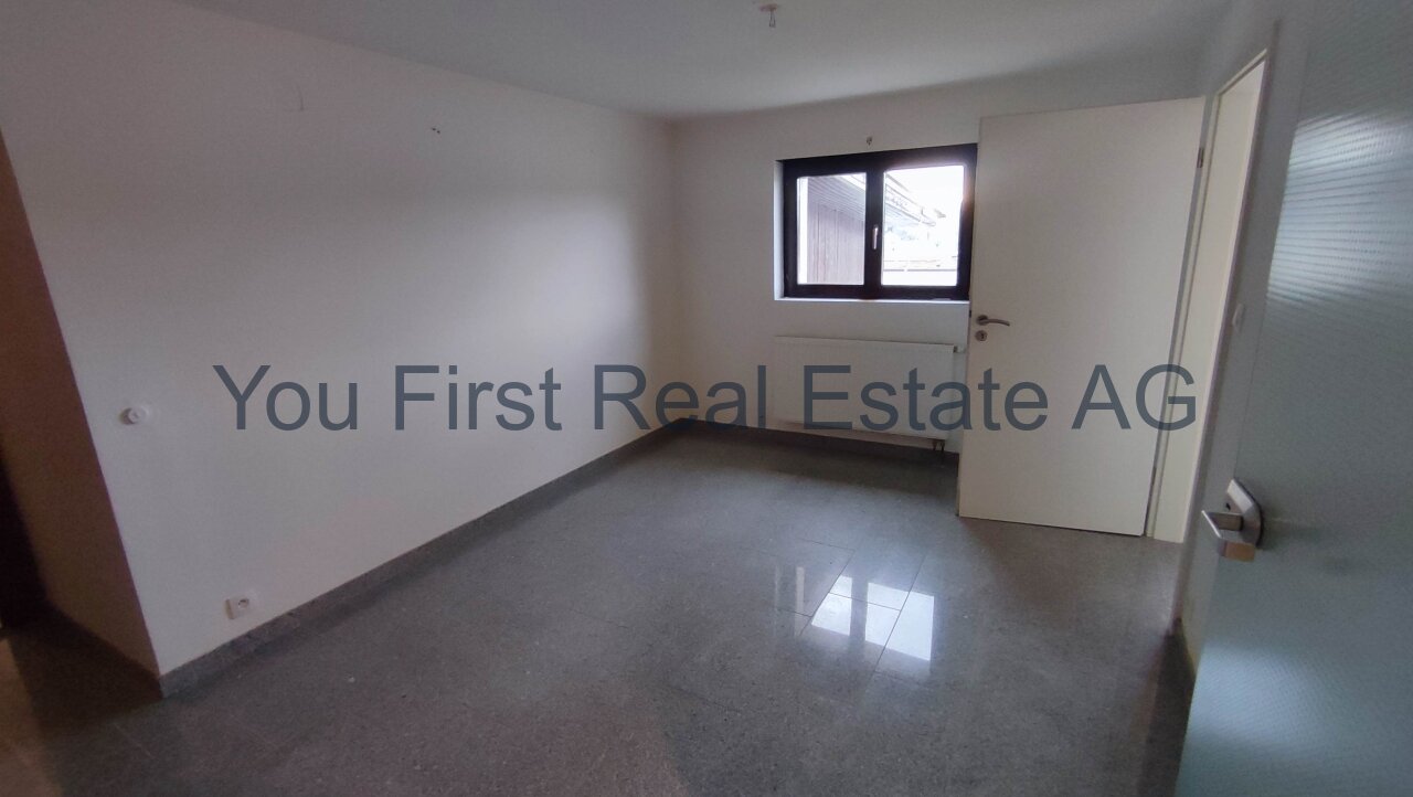 Lichtdurchflutetes Zimmer mit glänzender Granitboden-Optik und praktischem Heizkörper