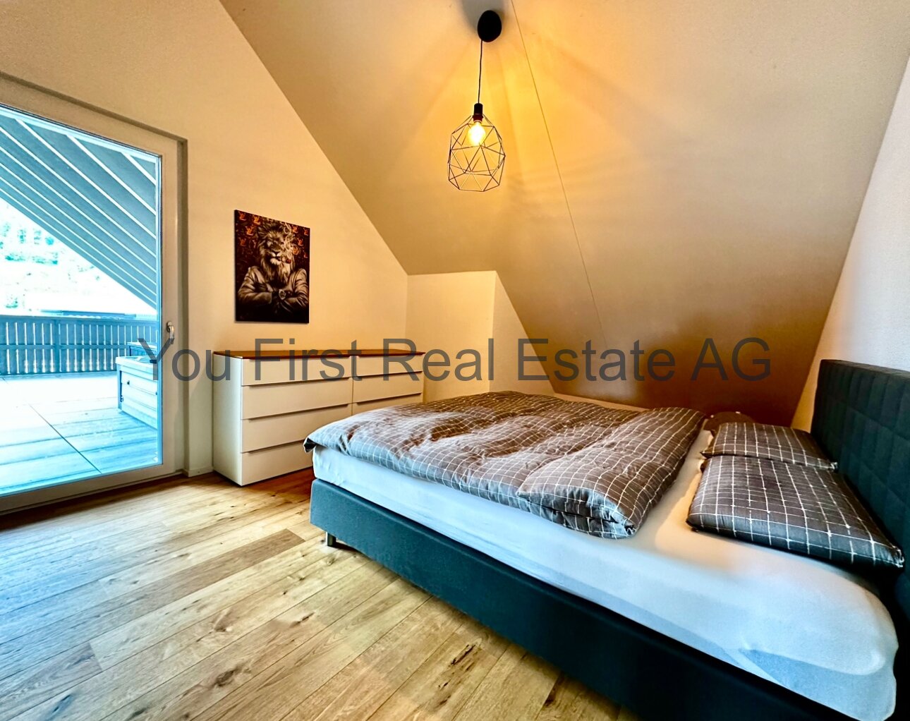 Lichtdurchflutetes Dachgeschlafzimmer mit Balkonzugang und Design-Pendelleuchte