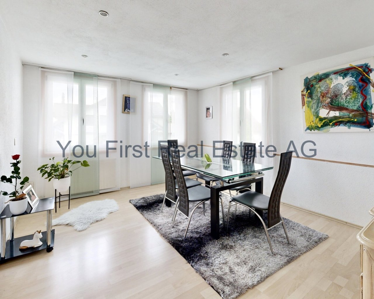 Lichtdurchfluteter Essbereich mit bodentiefen Fenstern und elegantem Glasdesign-Esstisch