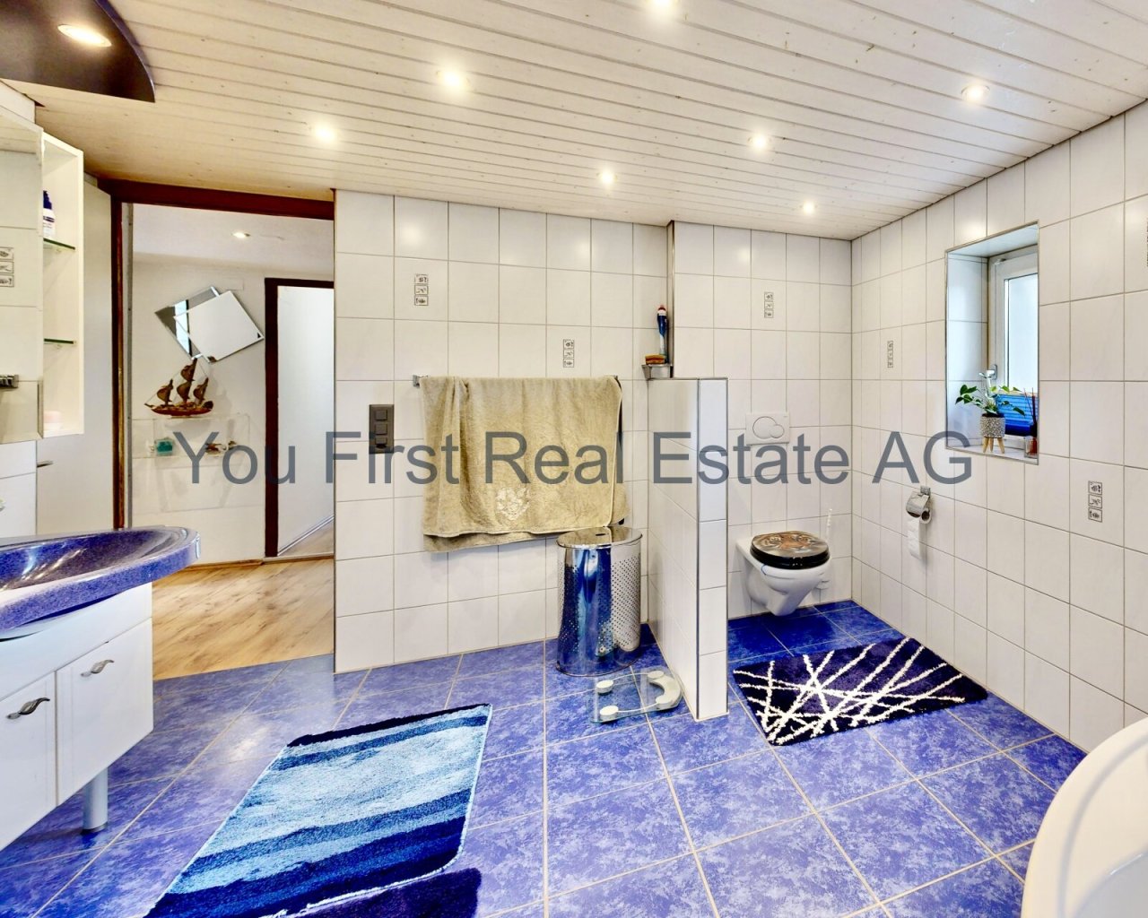 Modernes Badezimmer mit Komfort: Lichtdurchfluteter Wellness-Bereich mit blauer Akzentuierung