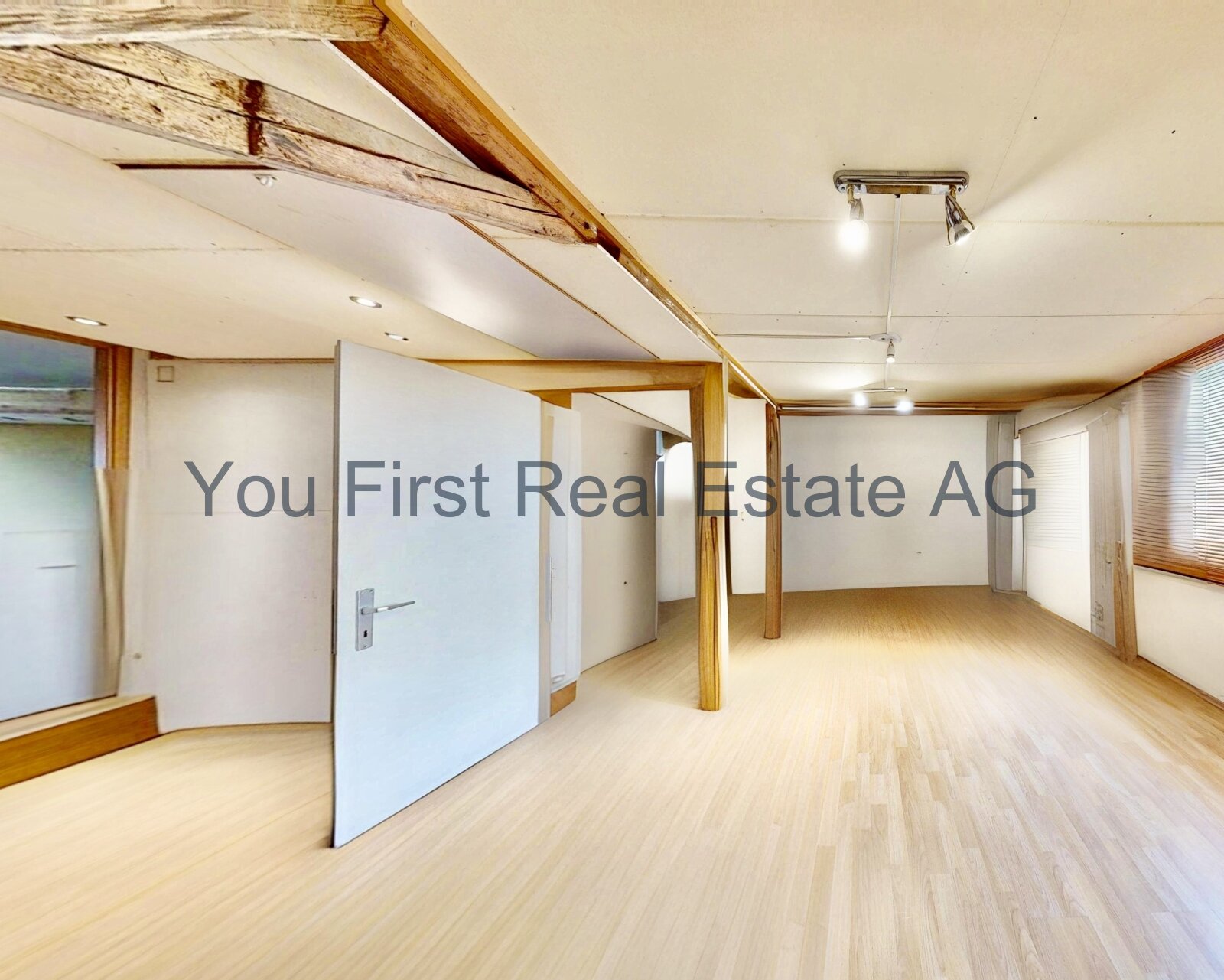 Charme der Altbausubstanz: Offene Dachgeschoss-Etage mit rustikalen Holzbalken und moderner Raumaufteilung