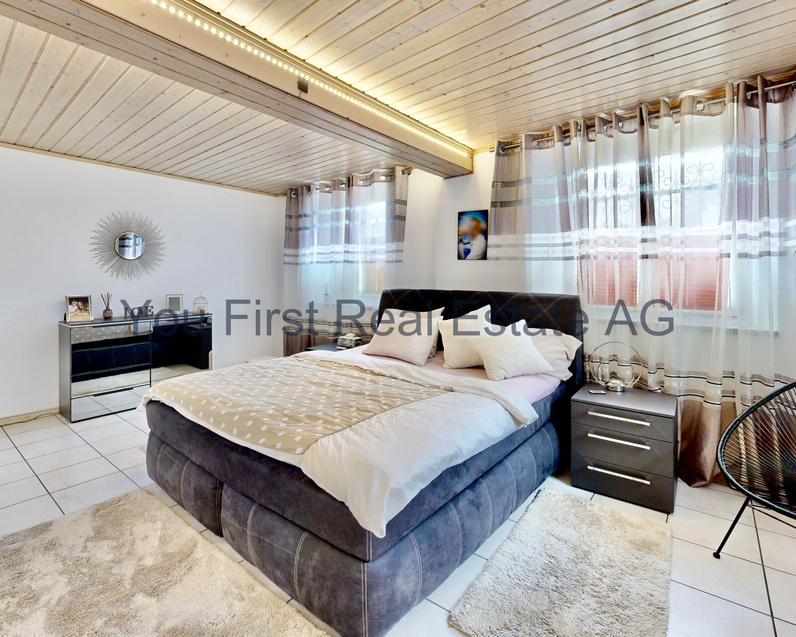 Helles Hauptschlafzimmer mit Holzdecke und großflächigen Fensterflügeln