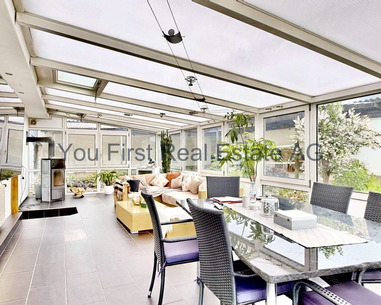 Lichtdurchfluteter Wintergarten: Moderne Wohlfühloase mit Panoramaverglasung und integriertem Kaminofen