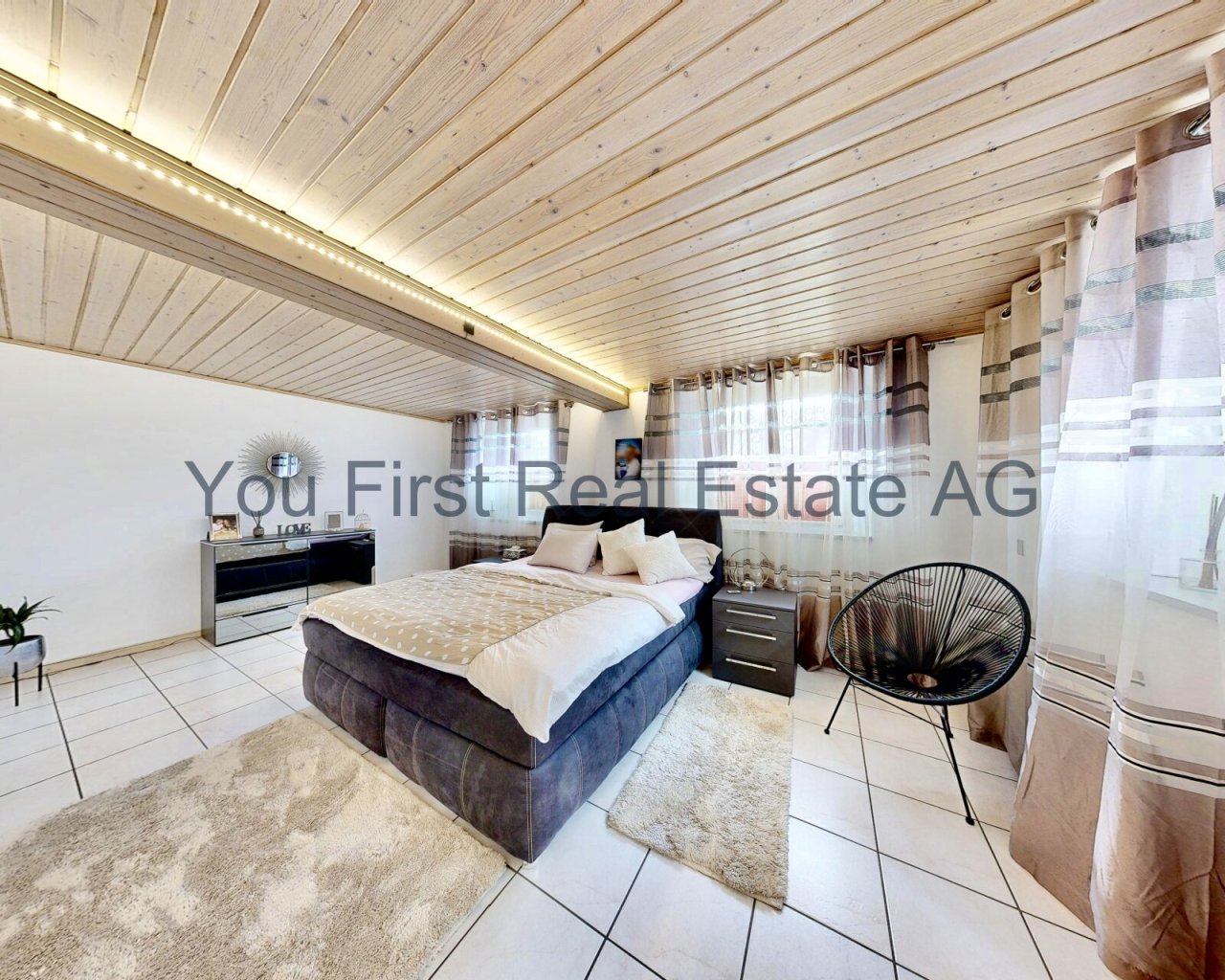 Lichtdurchflutetes Schlafzimmer mit stimmungsvoller Holzdecken-Beleuchtung und großzügigem Boxspringbett