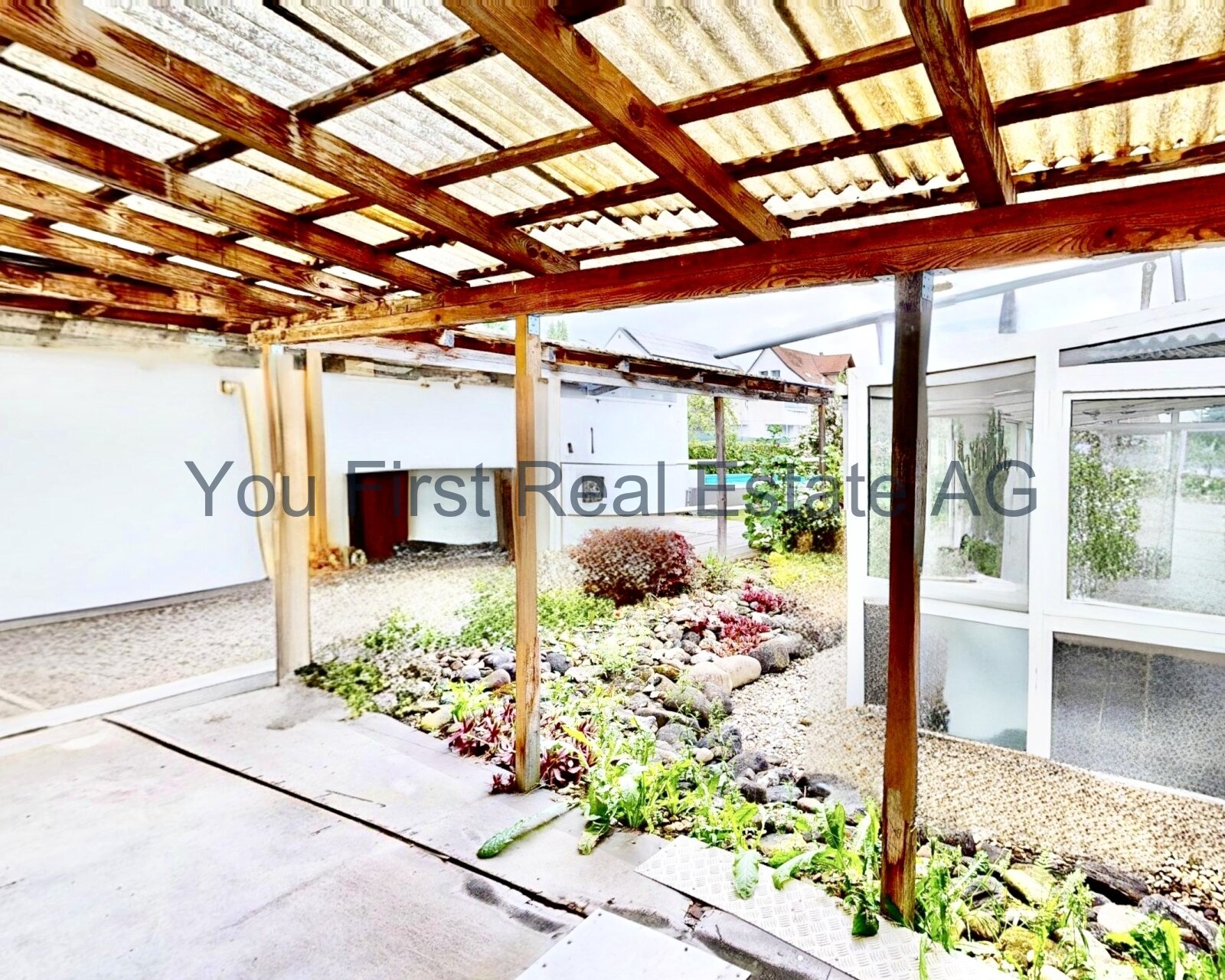 Überdachter Innenhof mit Holzkonstruktion und direktem Gartenzugang