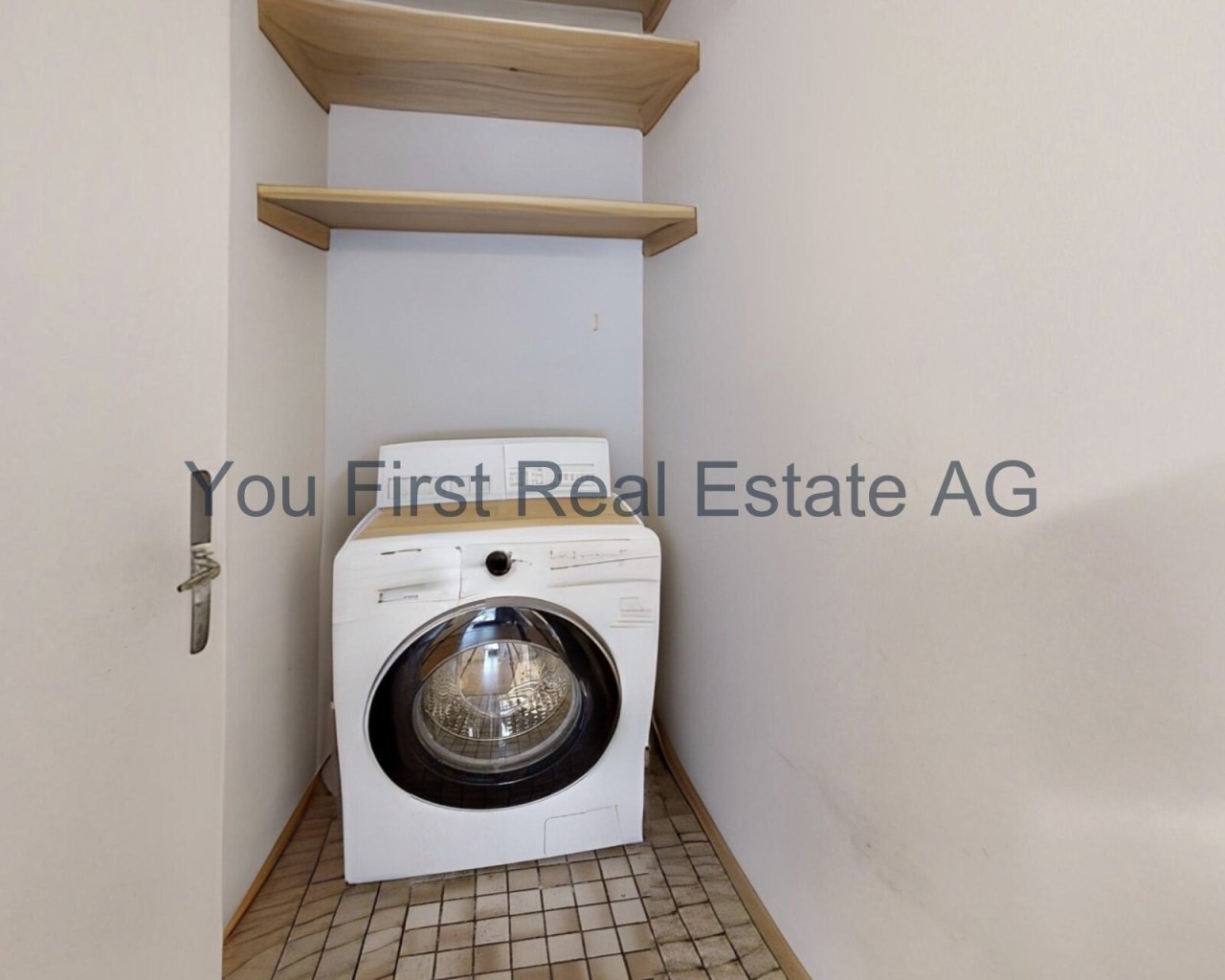 Praktischer Hauswirtschaftsraum mit integrierter Waschmaschine und eleganten Holzablagen