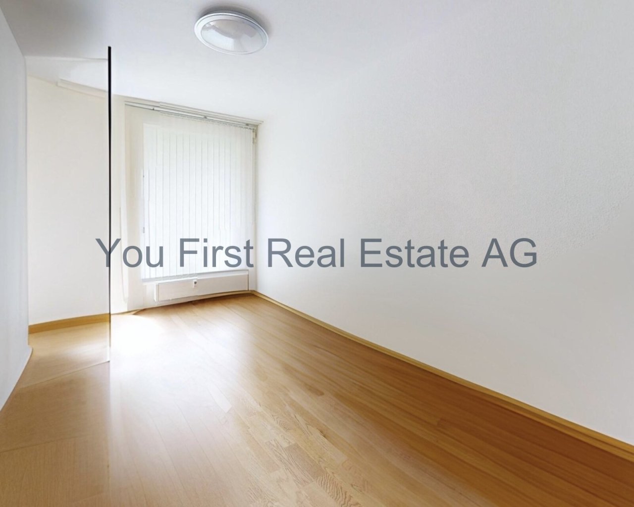 Lichtdurchfluteter Raum mit elegantem Holzboden und praktischer Wandheizung