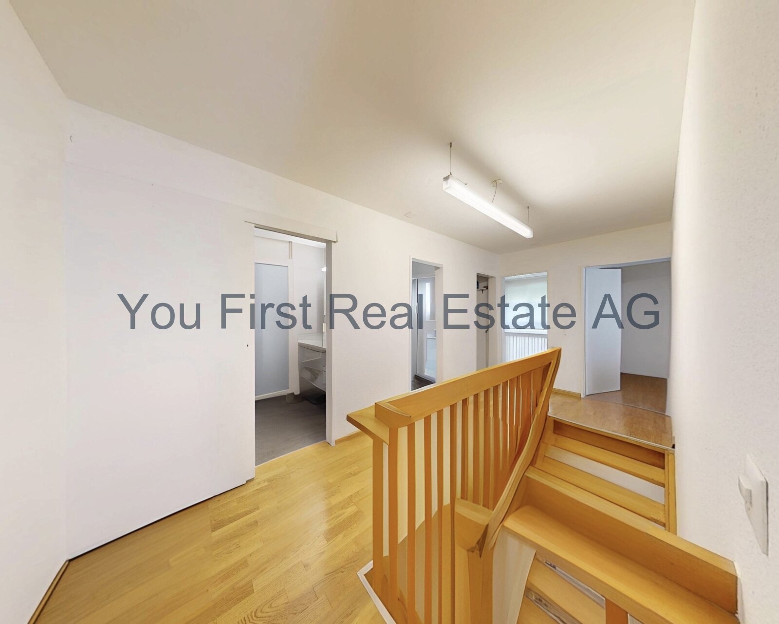 Lichtdurchfluteter Dachgeschoss-Flur mit hochwertiger Holztreppe und praktischen Anschlussräumen