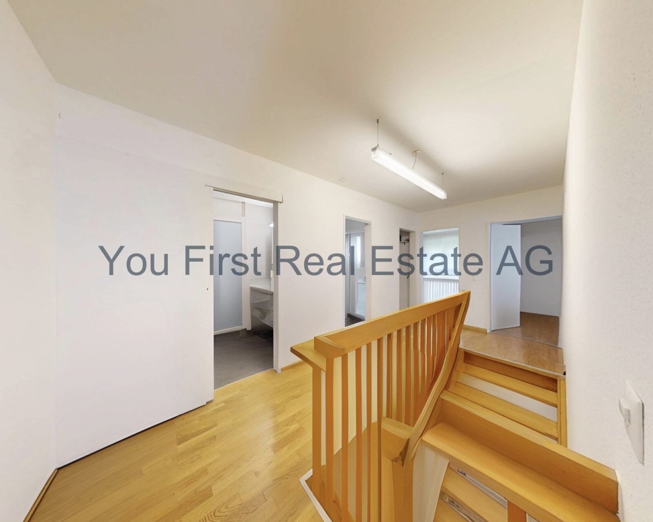 Lichtdurchfluteter Dachgeschoss-Flur mit hochwertiger Holztreppe und praktischen Anschlussräumen