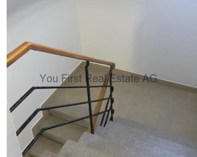 Komfortabel und sicher: Moderne Treppenanlage mit elegantem Holzhandlauf und stabilem Metallgeländer