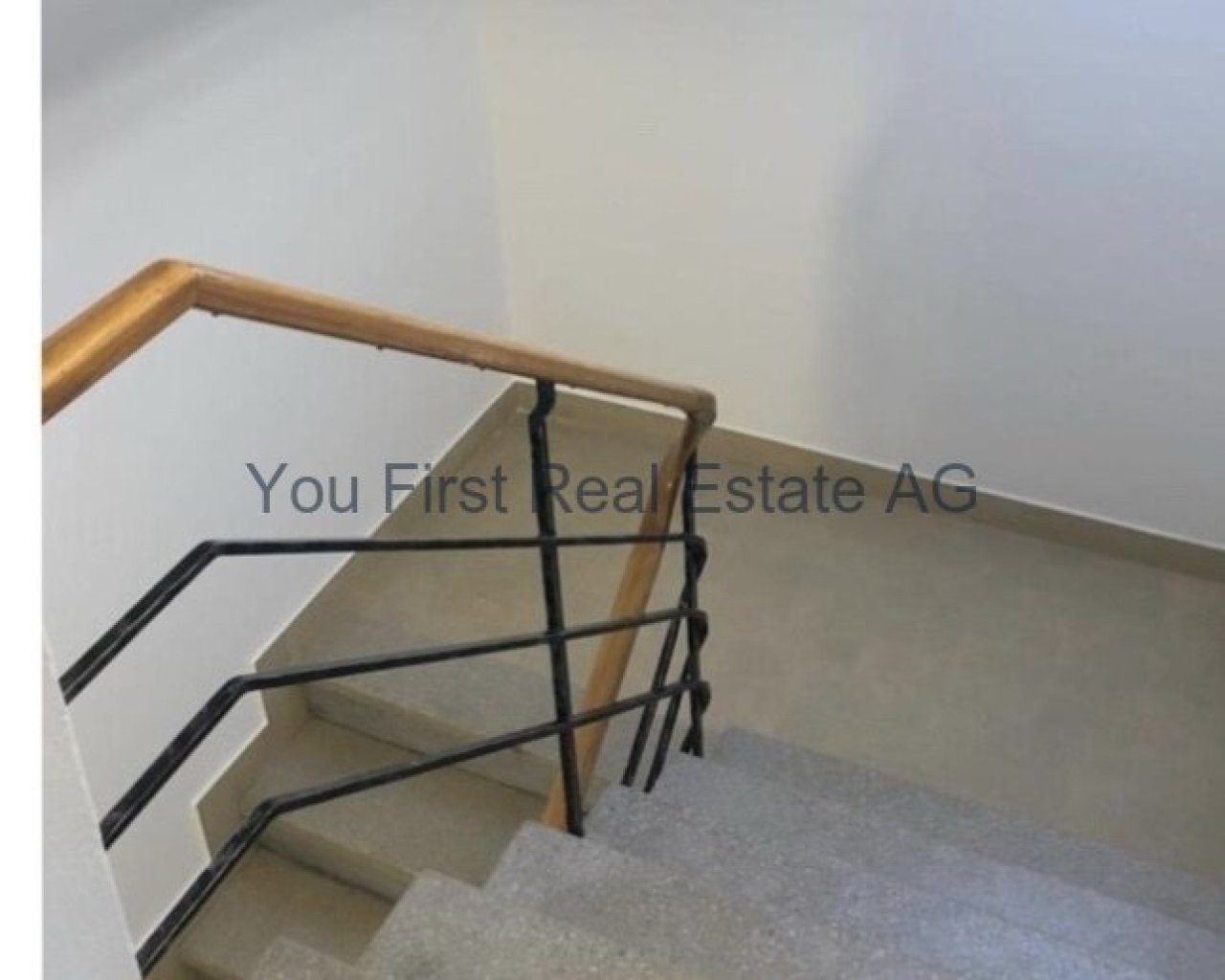 Komfortabel und sicher: Moderne Treppenanlage mit elegantem Holzhandlauf und stabilem Metallgeländer