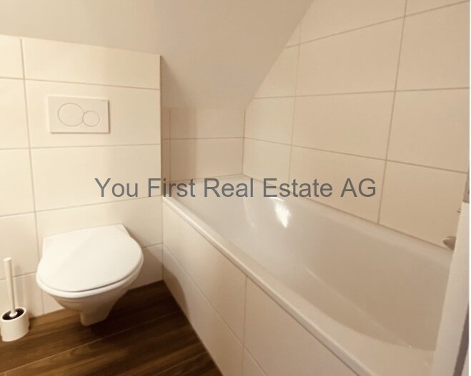 Modernes Badezimmer mit Komfort: Wandhängende Sanitäreinrichtungen und edle Holzoptik-Bodenbelag