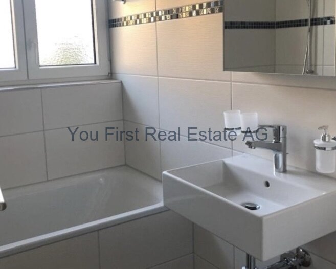 Modernes Badezimmer mit Design-Waschbecken und Naturlicht-Fenster