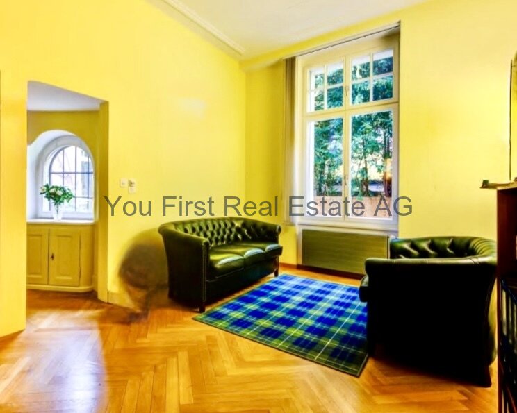 Stilvolles Altbau-Wohnzimmer mit Bogenfenster und elegantem Parkettboden - Lichtdurchfluteter Charme mit historischem Ambiente