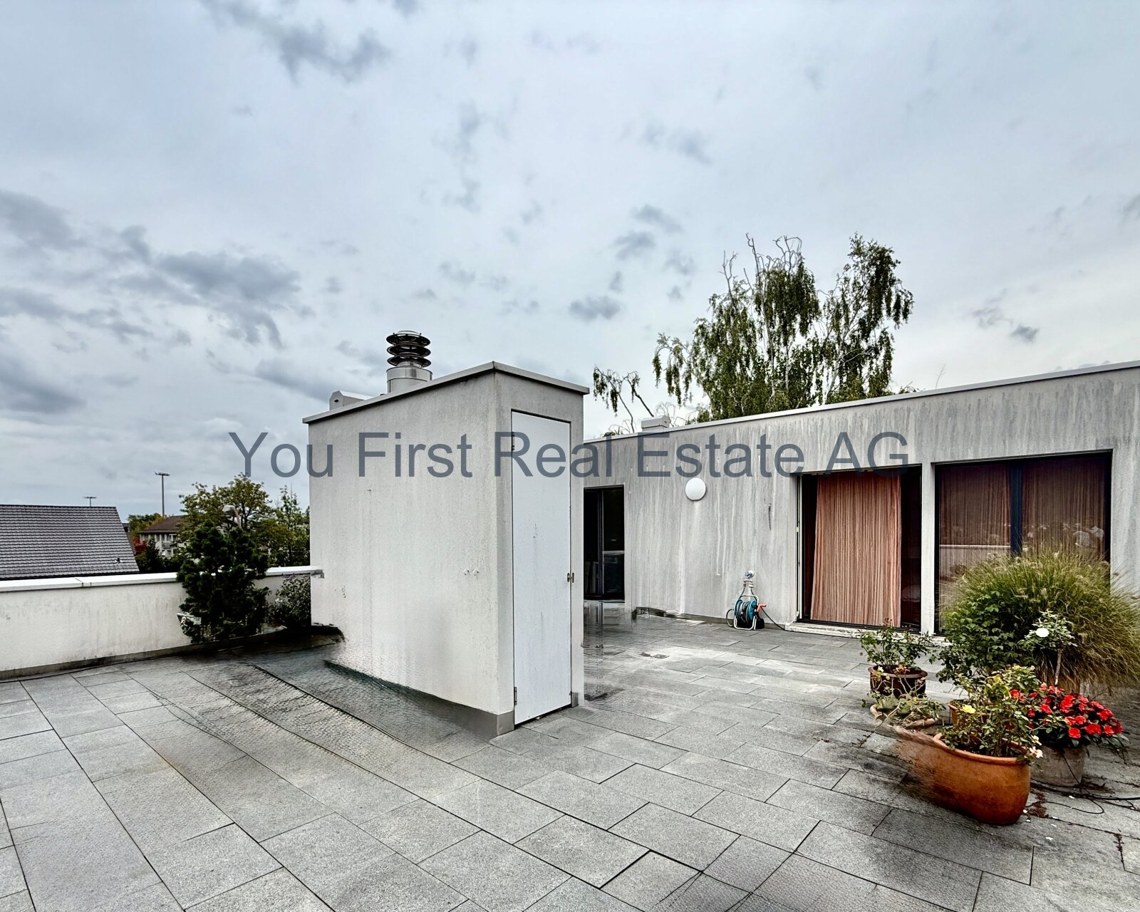 Exklusive Dachterrasse mit hochwertiger Natursteinverlegung und elegantem Architektur-Design