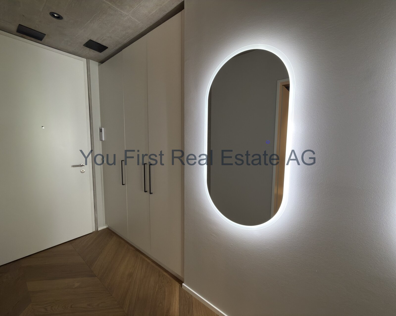 Design-Highlight: Beleuchteter Flur mit maßgefertigten Einbauschränken und elegantem Designspiegel