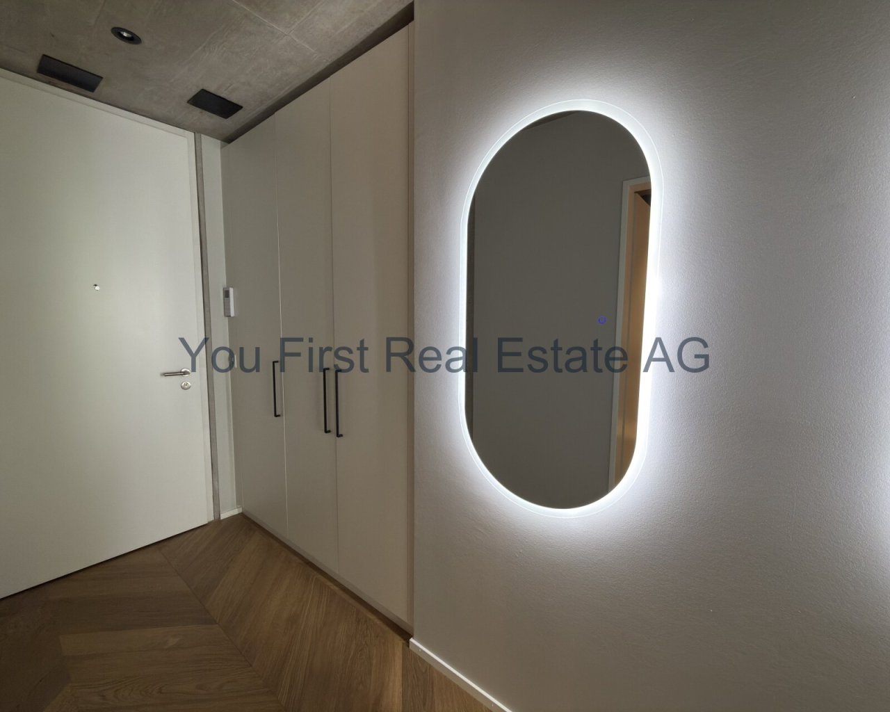 Design-Highlight: Beleuchteter Flur mit maßgefertigten Einbauschränken und elegantem Designspiegel