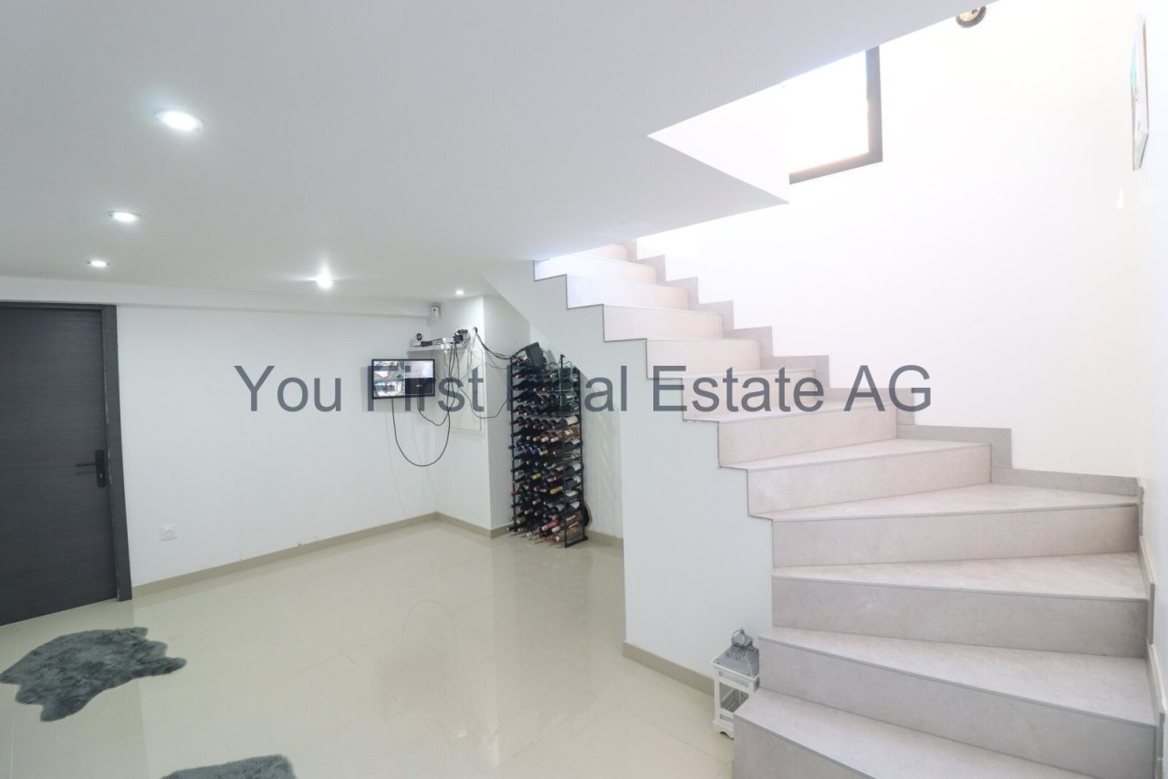 Moderner Kellerbereich mit eleganter Natursteintreppe und integrierter Sicherheitsausstattung