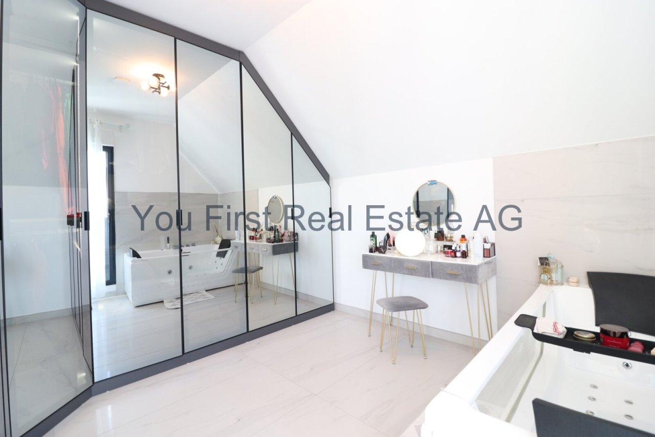 Luxuriöses Ankleidezimmer mit maßgefertigter Spiegelfront und integrierter Schminkstation