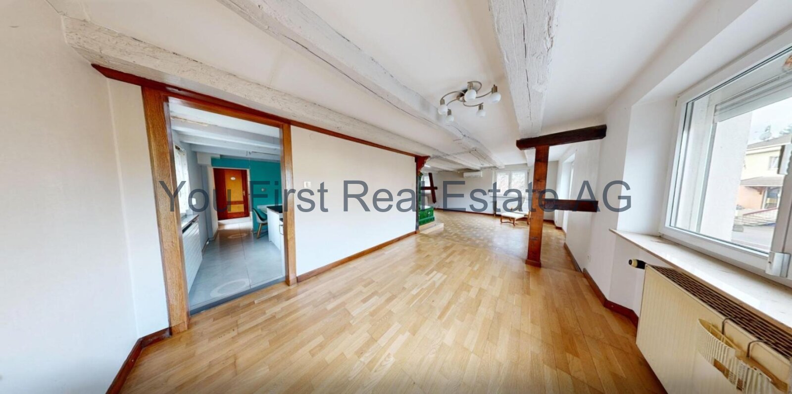 Loft-ähnlicher Wohnbereich mit Sichtbalken und offener Raumstruktur